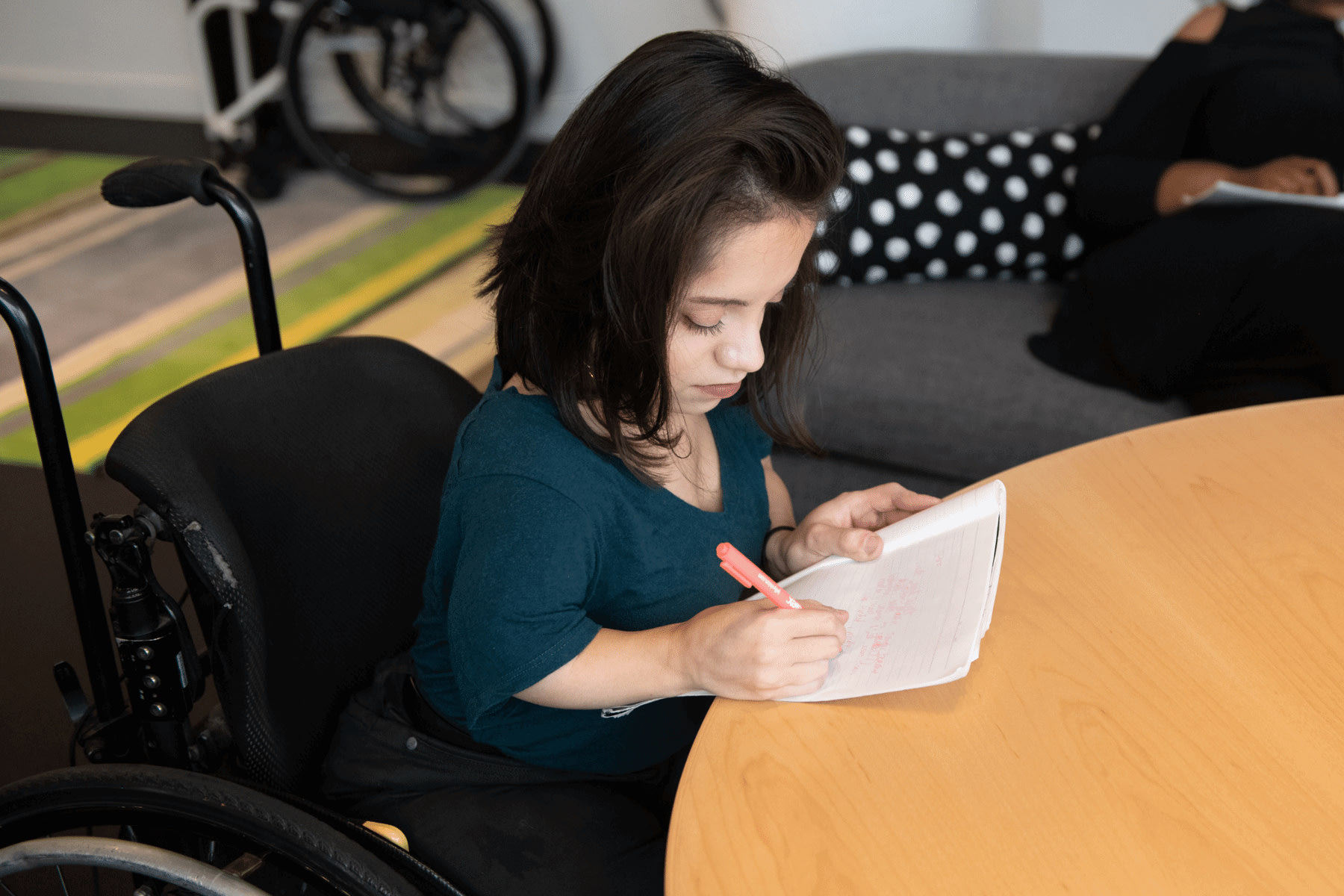 Women writing at a desk. Photograph: Disabled and Here