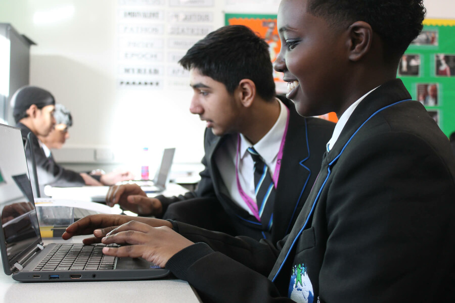 Two boys working on laptops in a classroom, taking part in a Media Literacy workshop