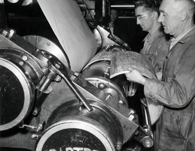 Printing the Manchester Guardian, nd [c1940s-c1950s]. Machine room - fitting a plate on to the rotary presses ready for printing. Stamped Manchester Guardian copyright. Archive ref: GUA-6-9-1-4-G box 3. Photograph: The Manchester Guardian